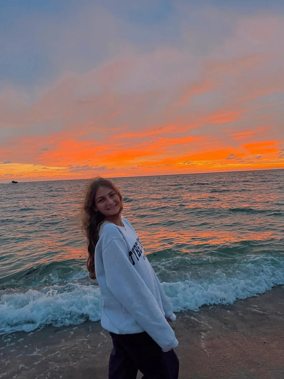 Julia, the Southwest Florida photographer behind Julia Faith Photography, smiling on the beach at sunset